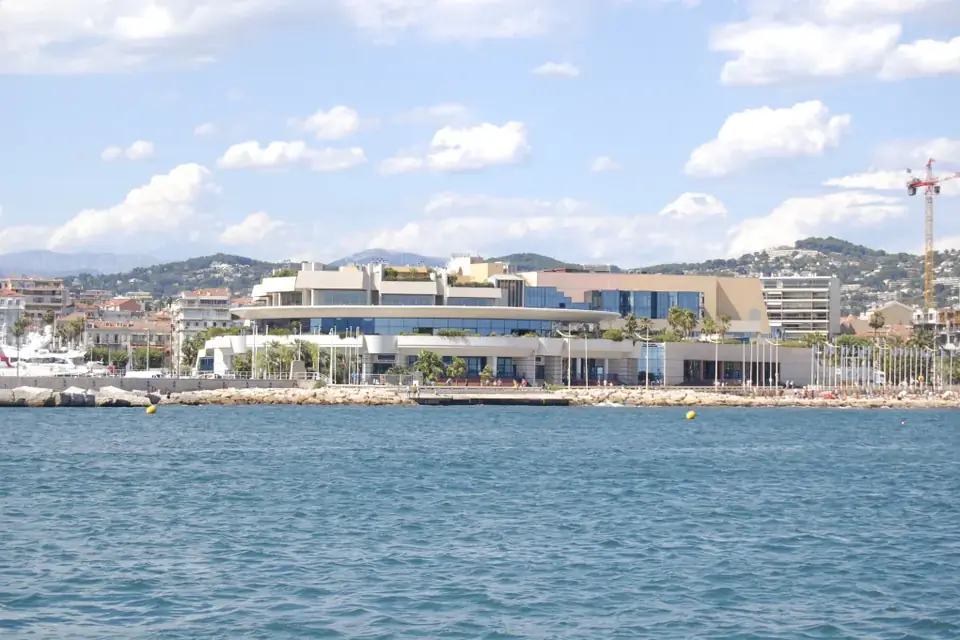 Le Palais des Festivals et des Congrès de Cannes vu depuis la mer, avec les collines en arrière-plan